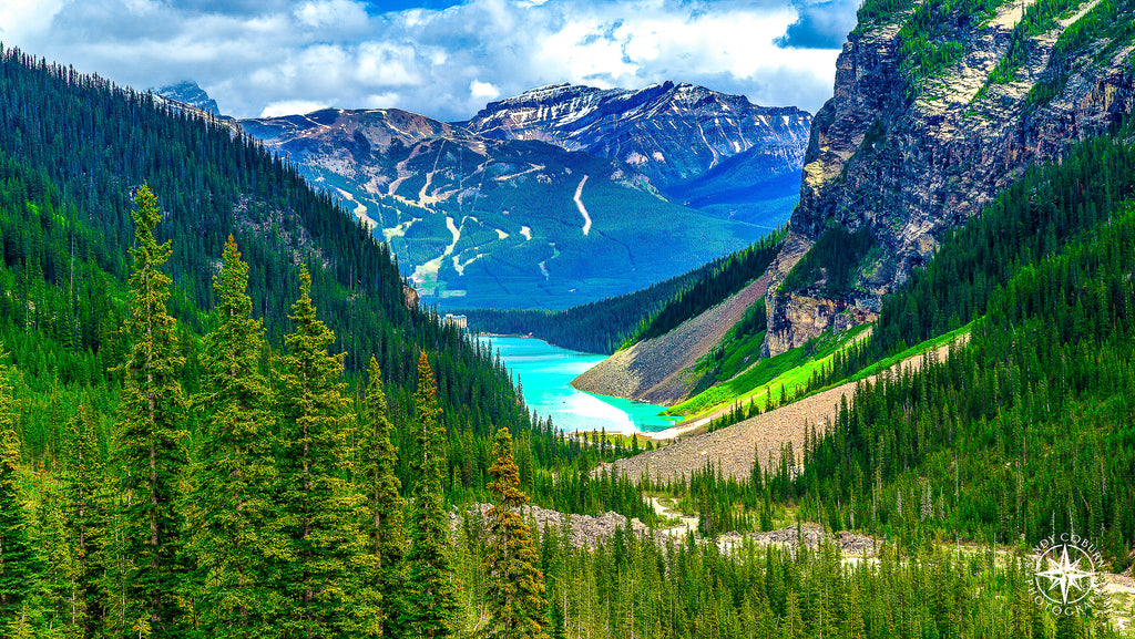 View from a glacier overlooking Lake Louise in Banff National Park, with a snow-capped mountain rising behind and the bright 