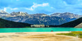 The Fairmont Château Lake Louise resort sits at the edge of a turquoise glacial lake, with towering mountain peaks in the ba