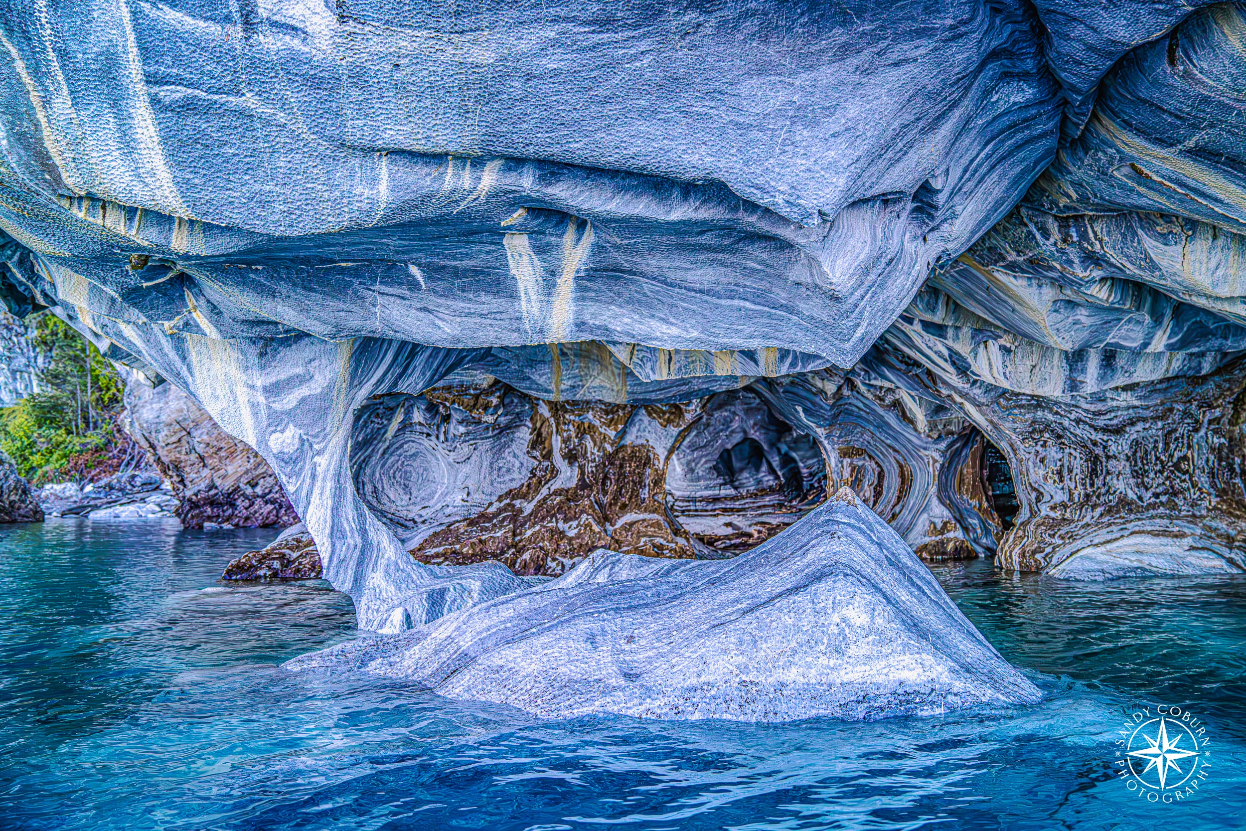 Massive marble formation balanced on a narrow stone pedestal, resembling a suspended weight inside a cave above General Carre