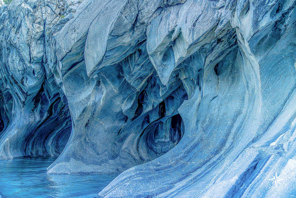 Interior view of marble cave with large teardrop-shaped opening and soft turquoise coloring.