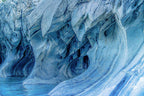 Interior view of marble cave with large teardrop-shaped opening and soft turquoise coloring.